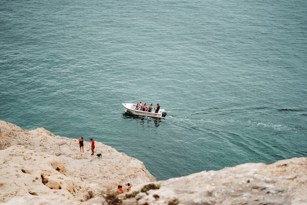 people riding on white and red boat on sea during daytime