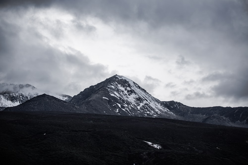 montagne enneigée sous un ciel nuageux pendant la journée