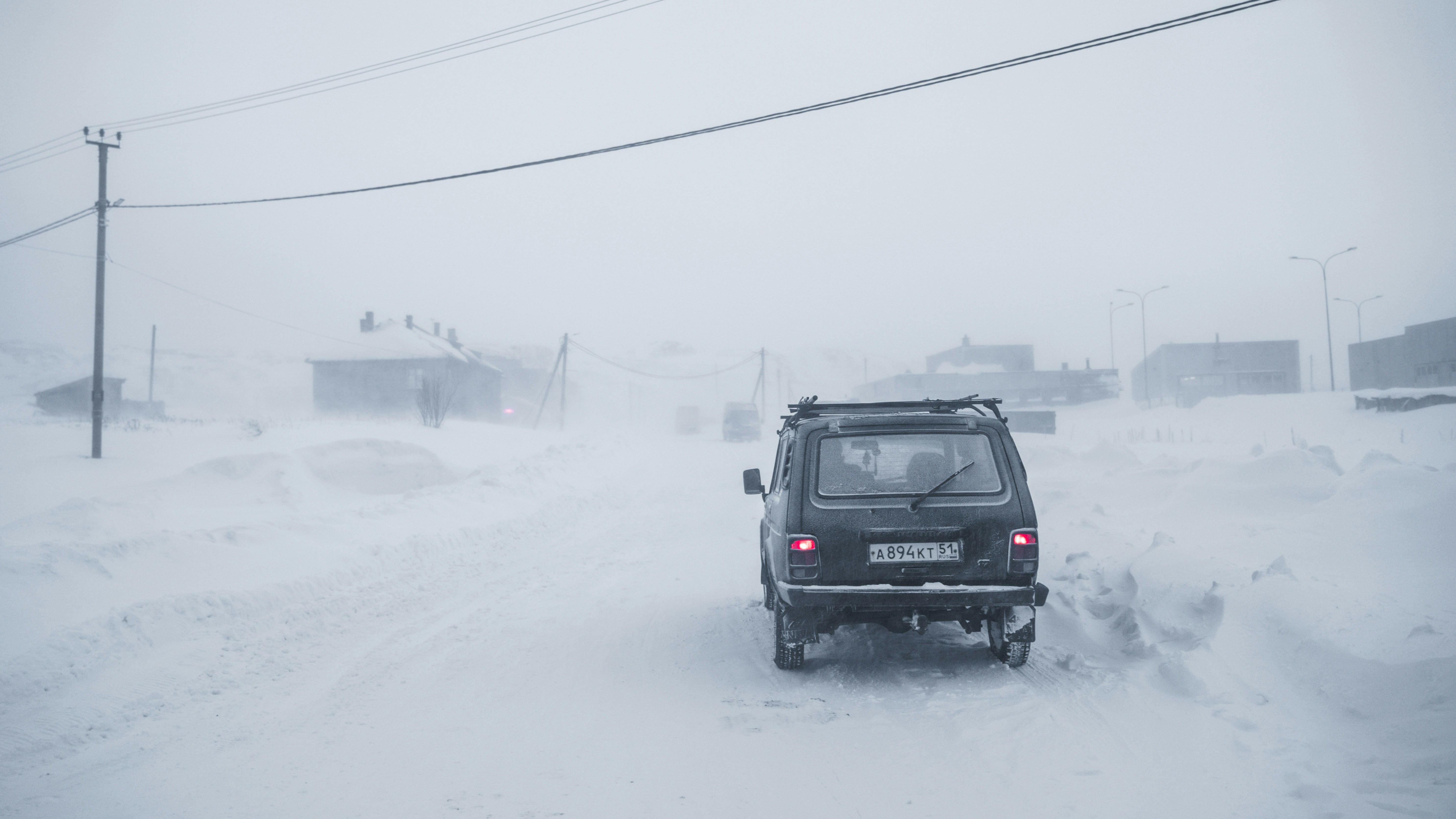 black suv on snow covered road during daytime