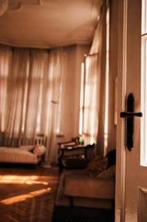 A bright and airy room filled with natural light and soft furnishings.