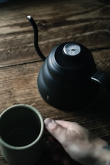 Infrared thermometer pointed at a steaming cup of coffee, capturing temperature without contact.