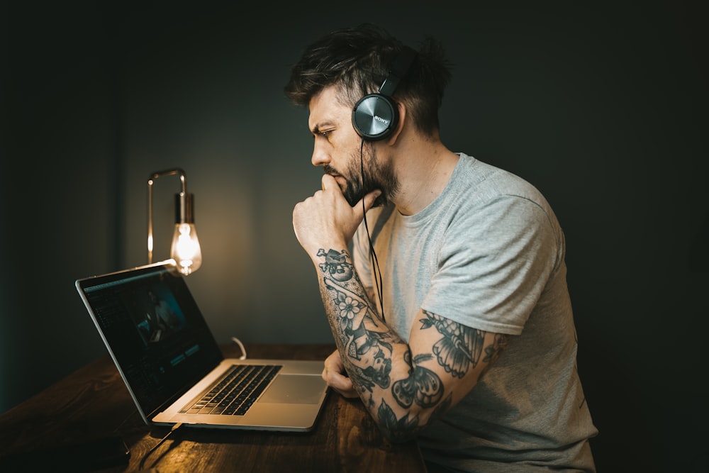 man in white crew neck t-shirt wearing black headphones