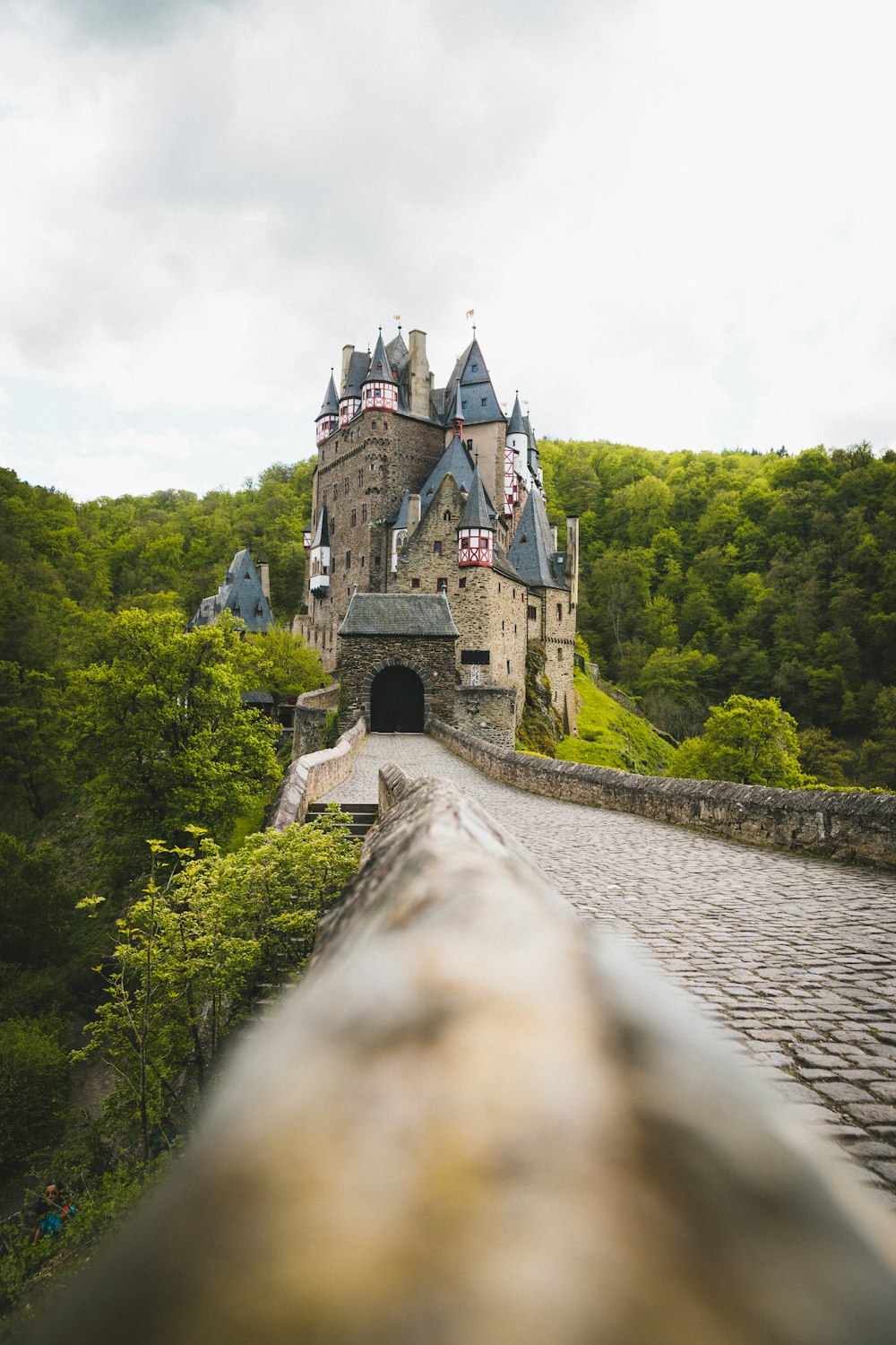 Château en béton gris près d’arbres verts pendant la journée