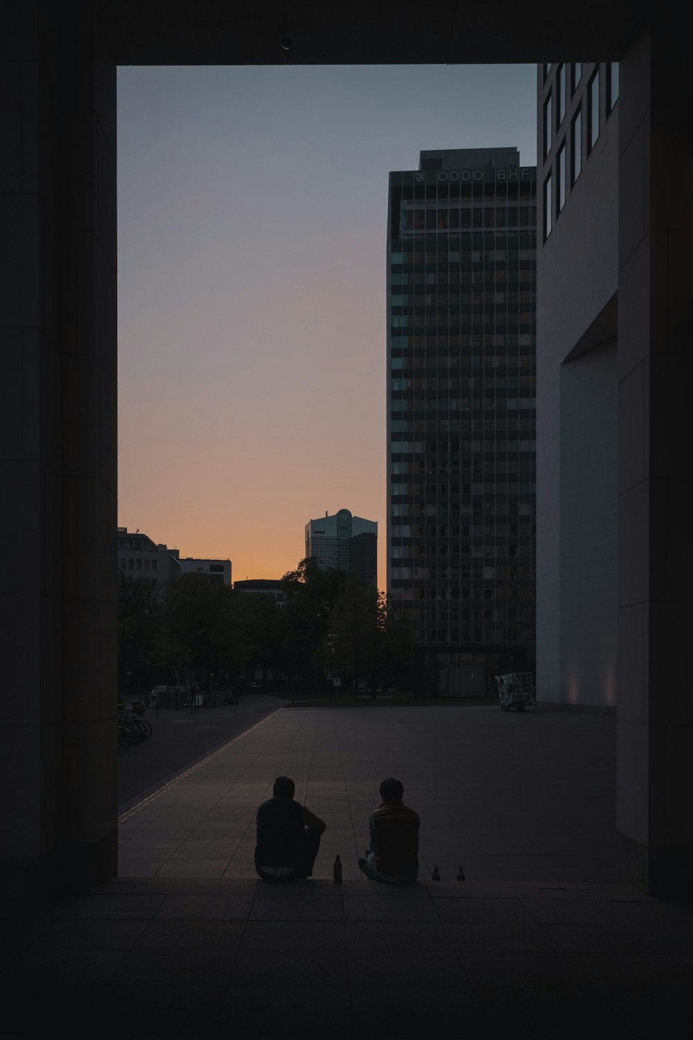 silhouette of man and woman walking on sidewalk during night time