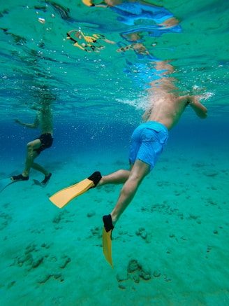 man in blue shorts swimming in water