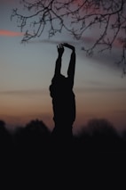 A peaceful moment of a person stretching at sunrise, embodying wellness and balance.