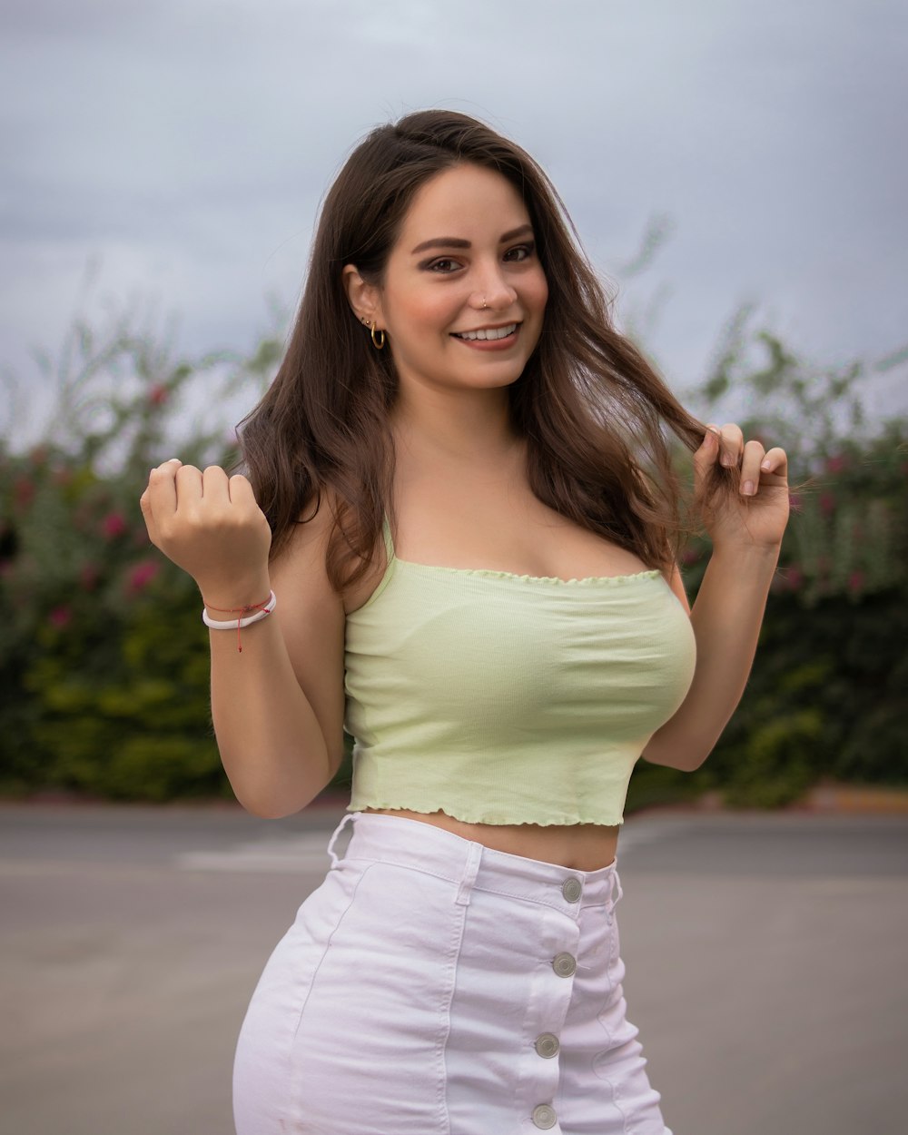 woman in white tank top and white shorts standing on road during daytime