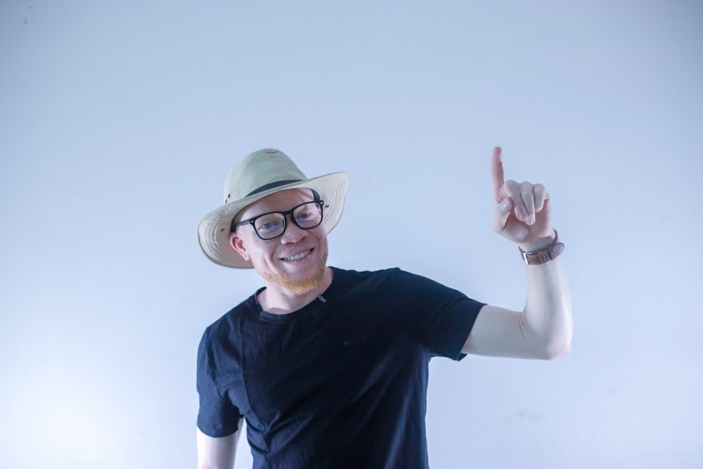 man in black crew neck t-shirt wearing green hat and eyeglasses