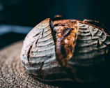 Close-up of rustic artisanal bread with natural light highlighting its texture.