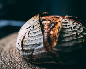 Close-up of rustic artisanal bread with natural light highlighting its texture.