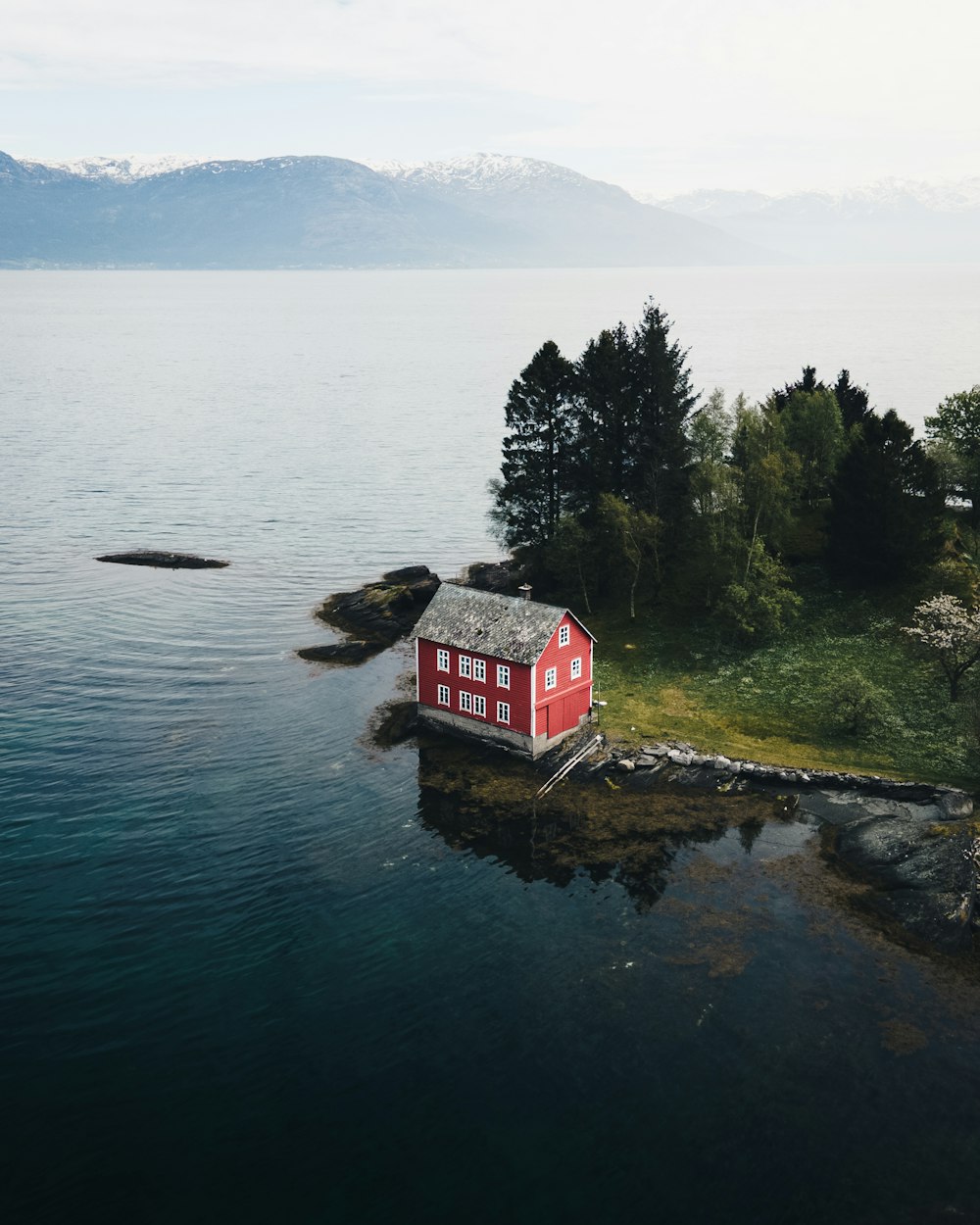 red and white house near body of water during daytime