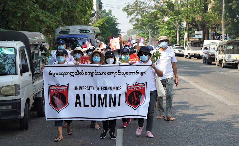 people holding white banner during daytime