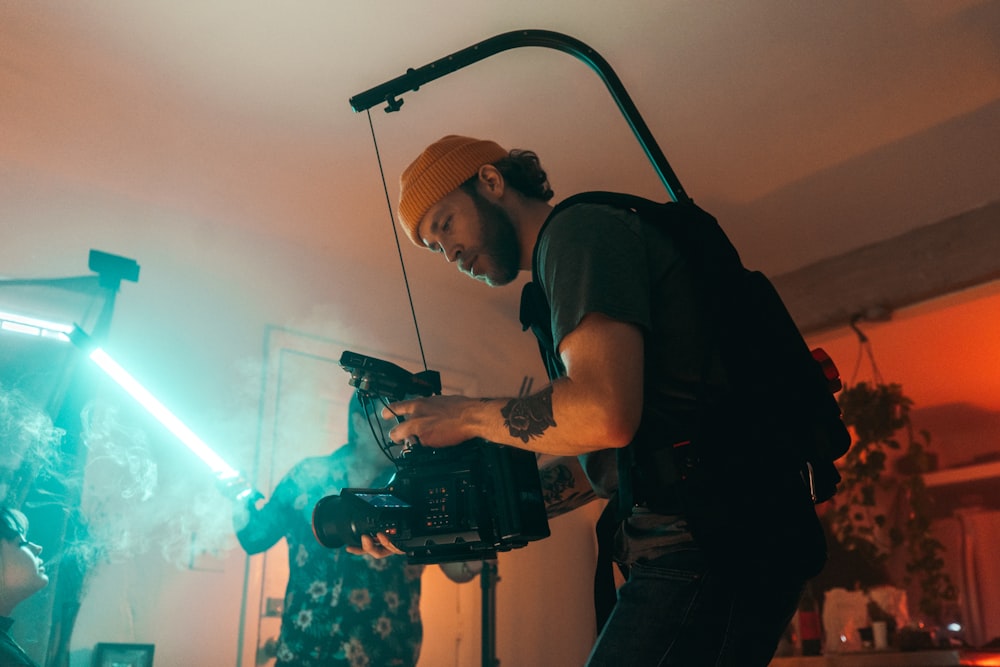 man in black t-shirt holding black video camera