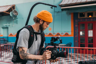 man in gray crew neck t-shirt holding black dslr camera