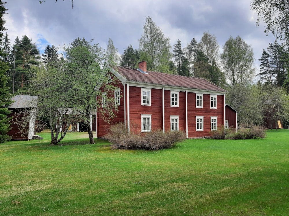 brown and white concrete house near green grass field during daytime