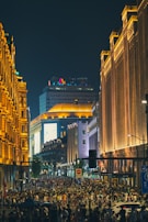A bustling city street filled with people and lights at night.