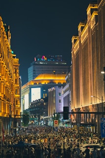 A bustling city street filled with people and lights at night.