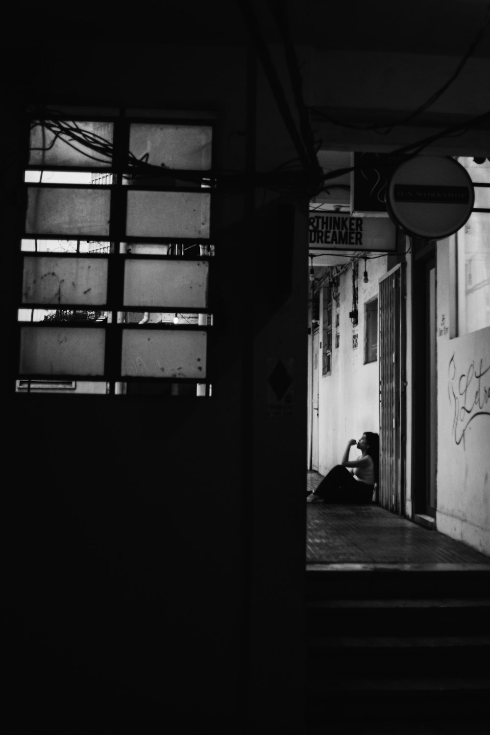 a black and white photo of a person sitting on the ground