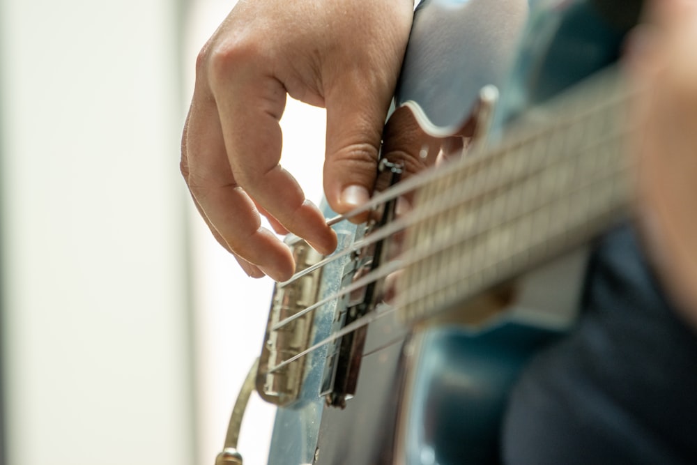 a person playing a guitar with their hands