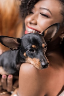 Smiling pet owner greeting her small dog after a safe ride with PetTransit.