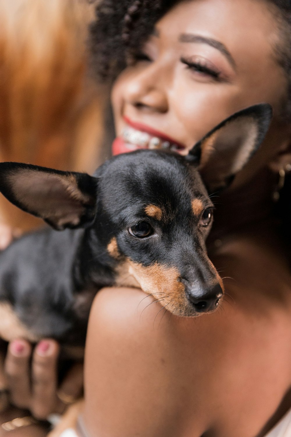 a woman holding a small black and brown dog