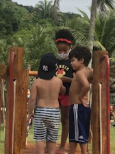 Group of children climbing tropical trees with smiles in a lush Martinique forest.