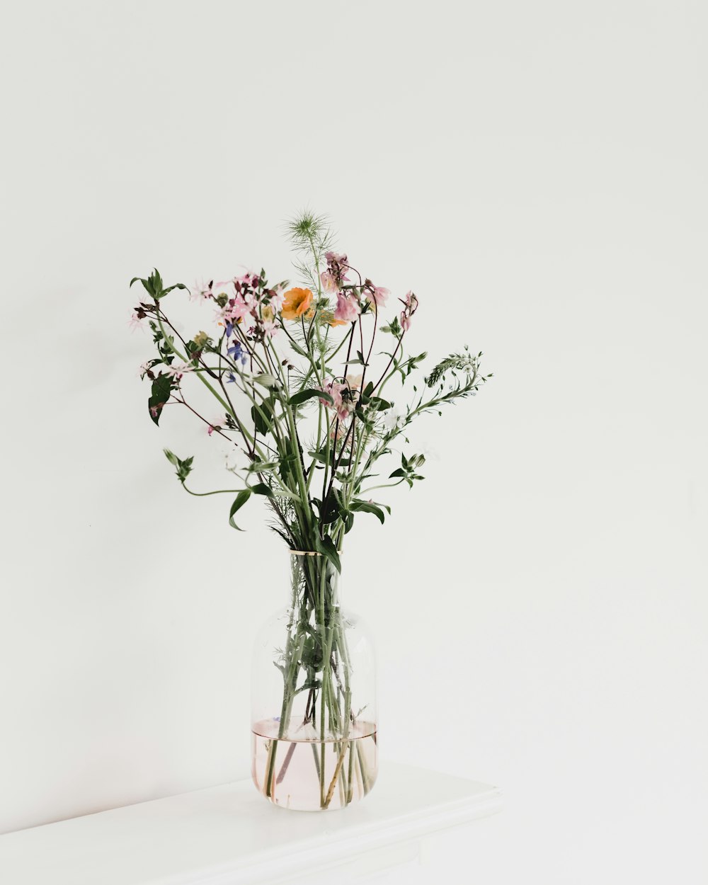 red and yellow flowers in clear glass vase