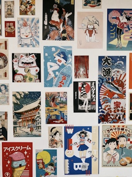 A collection of various Japanese-style posters and illustrations arranged in a collage. The images feature colorful and diverse themes, including traditional Japanese art, anime-style characters, and modern pop art elements. There are depictions of characters in dynamic poses, a Maneki-neko (lucky cat), and scenes with cultural motifs.