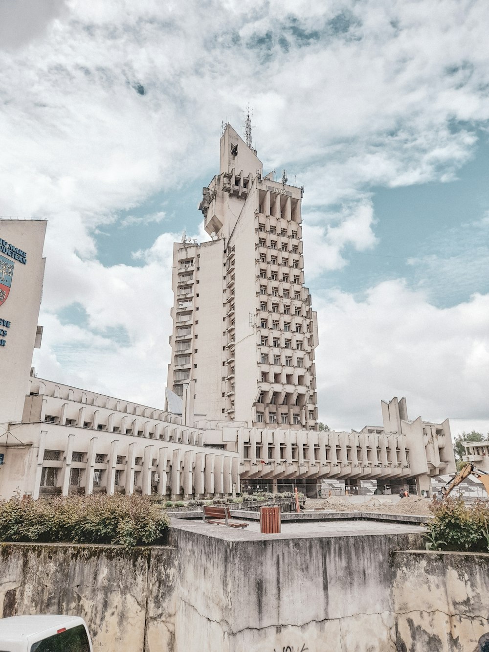 edifício de concreto branco sob nuvens brancas durante o dia