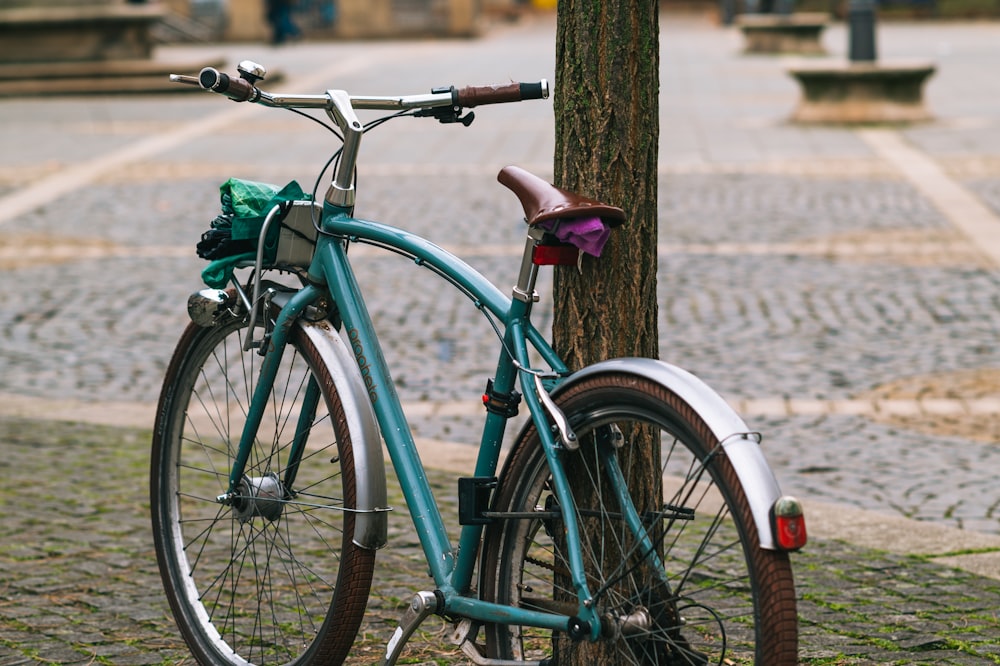 blue city bike leaning on brown wooden post