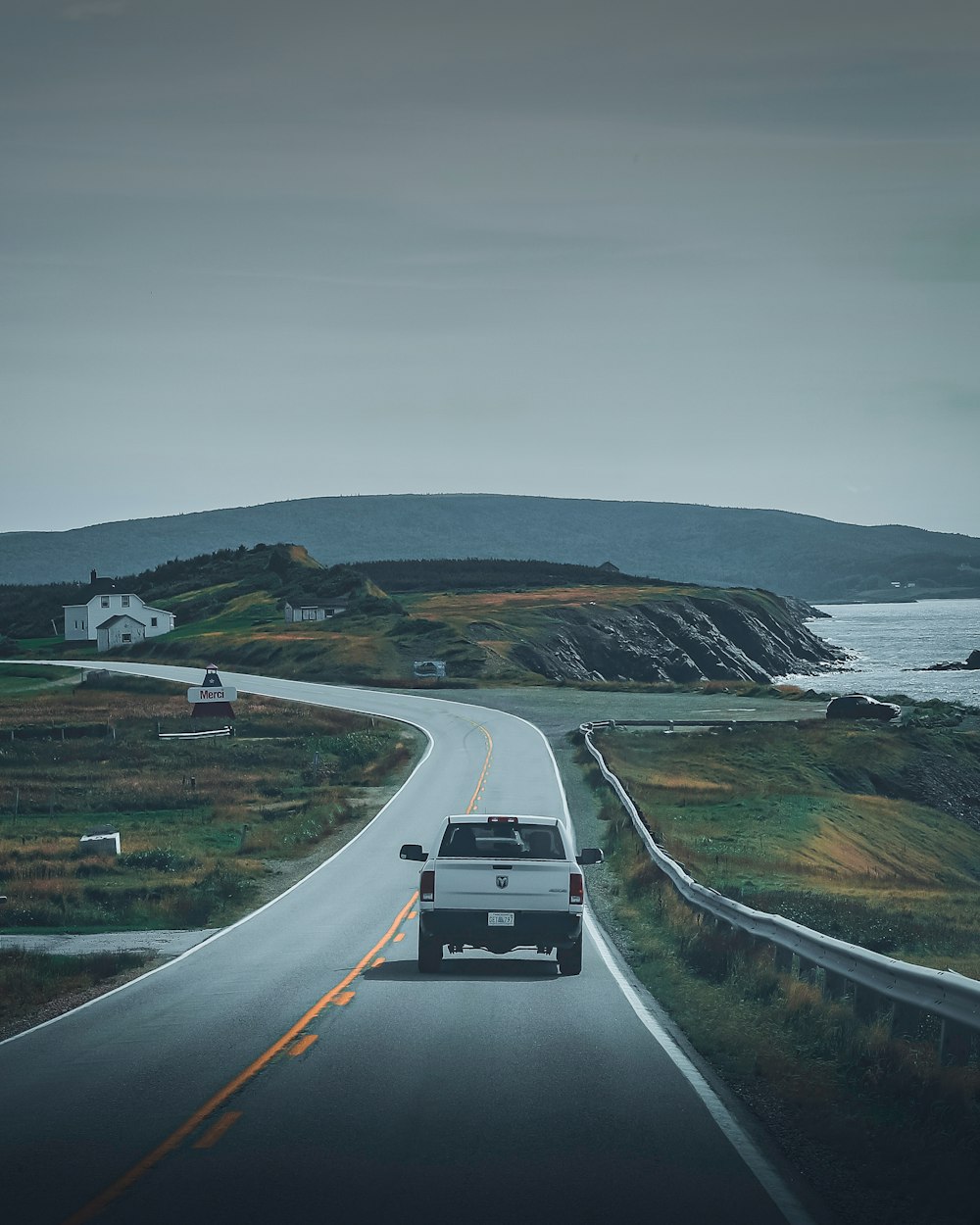 cars on road near body of water during daytime