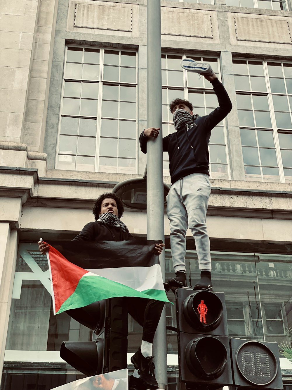 woman in black jacket and gray pants standing on gray metal pole during daytime