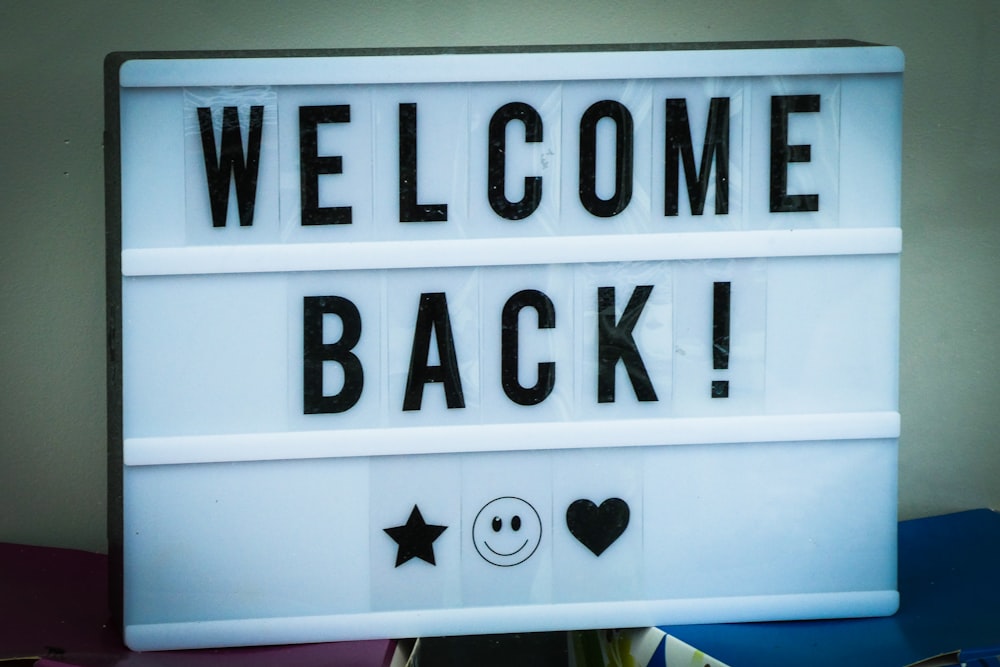 a welcome back sign with a smiley face