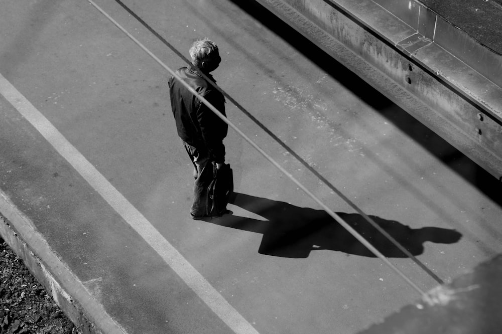 man in black jacket walking on the street