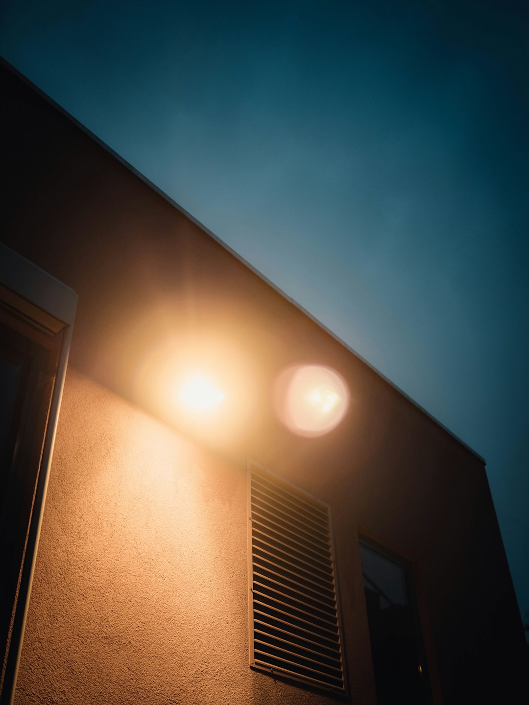 white ceiling lamp turned on near white window type air conditioner