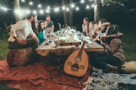 A group gathered around a traditional Polynesian meal, laughing and sharing stories under soft evening lights.