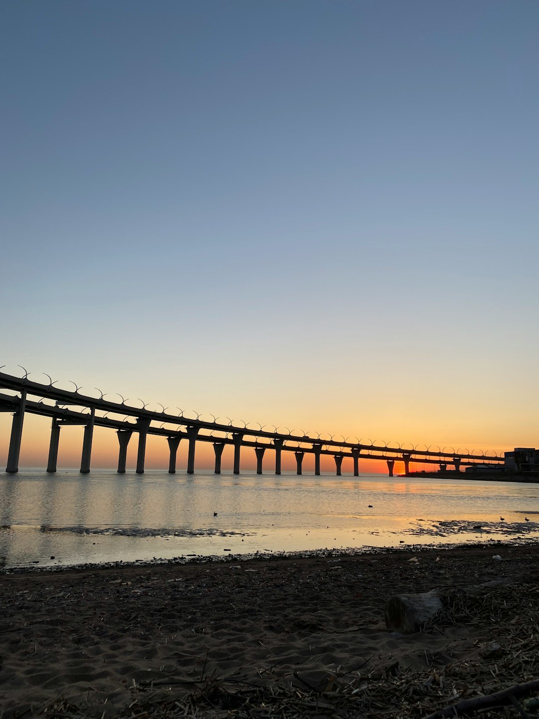 brown wooden bridge over the sea during sunset