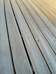 Close-up of a durable deck fastener being installed on wooden planks.