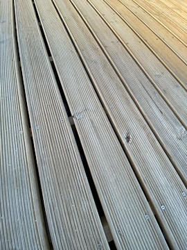 Close-up of a durable deck fastener being installed on wooden planks.