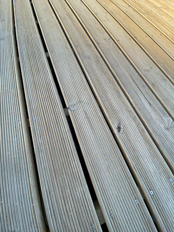 Close-up of skilled craftsmen installing deck boards with precision and care.
