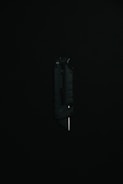 A black utility knife with a visible metal blade is placed upright against a dark background, highlighting its sleek and modern design.