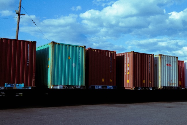 A blueline freight truck loaded with freight containers under a clear blue sky.