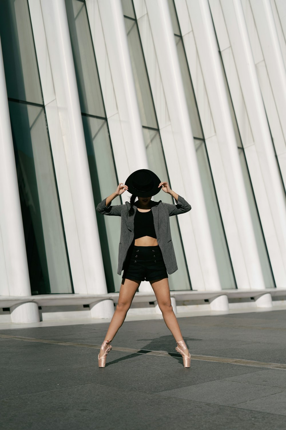 woman in black mini skirt and black hat walking on white floor