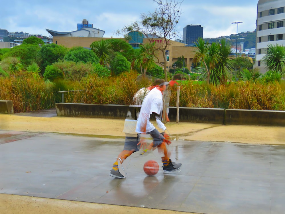 man in white t-shirt and white shorts playing basketball during daytime