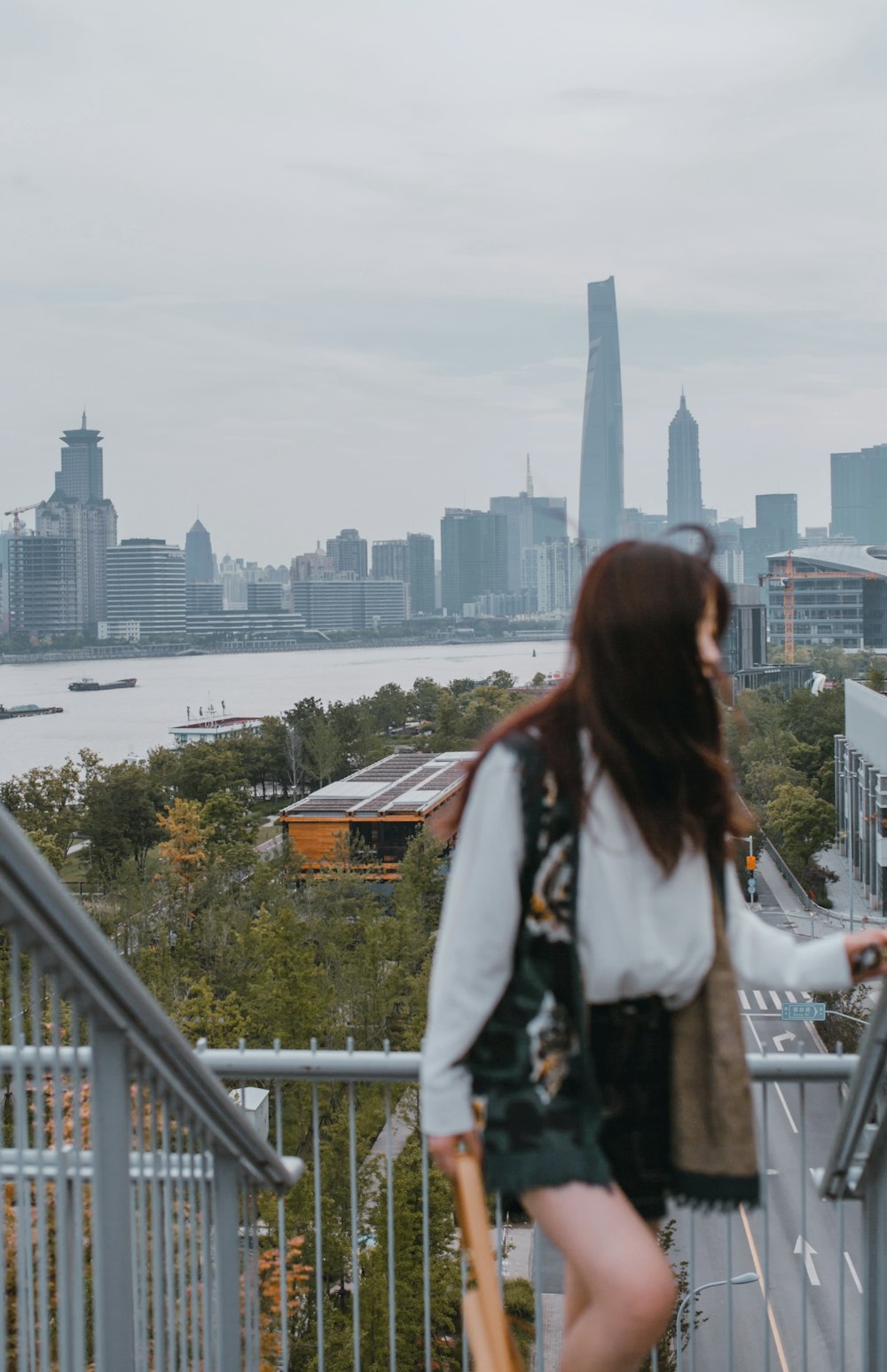 woman in white and black jacket standing on balcony during daytime