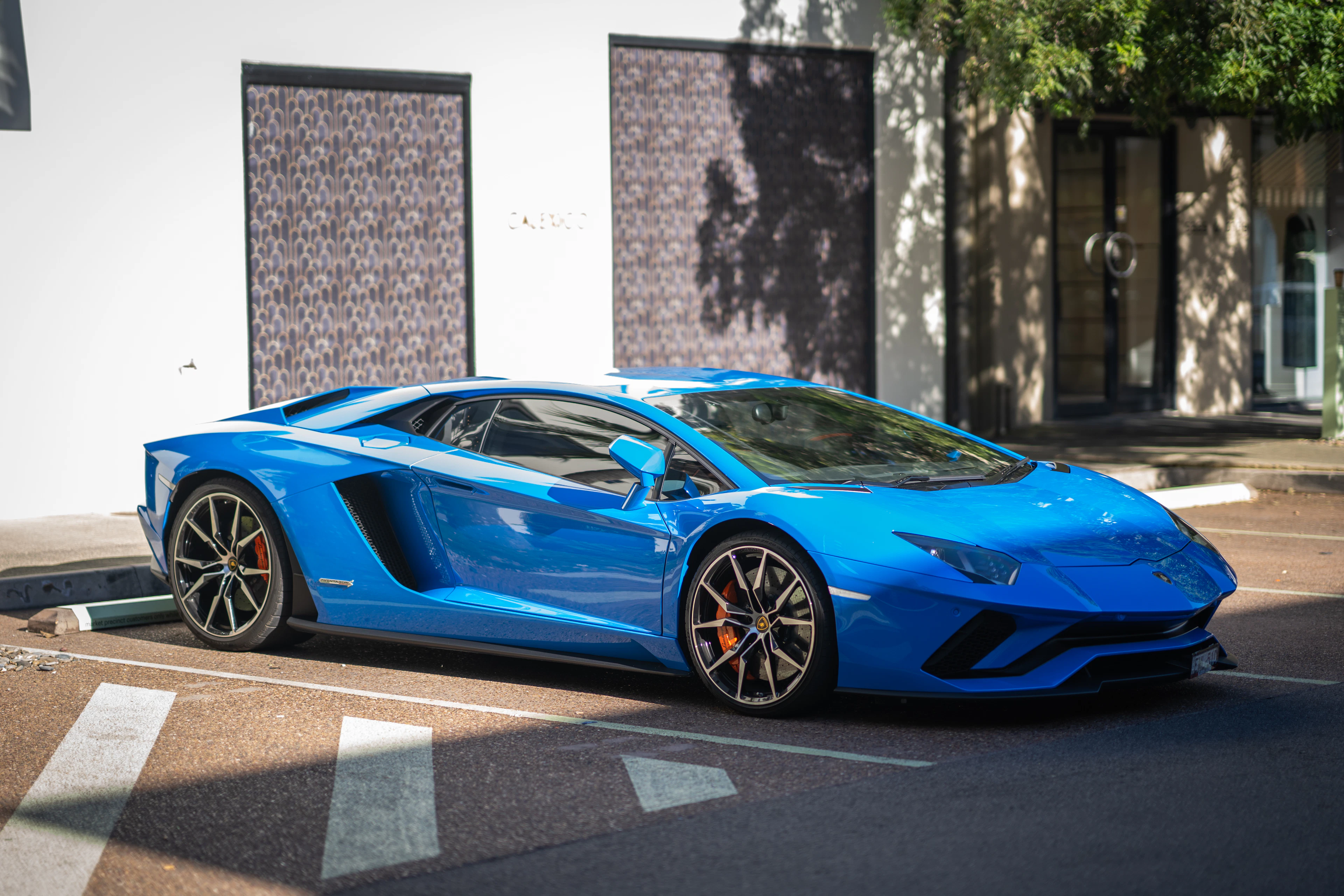 Lamborghini Aventador S blu parcheggiata in strada, pronta per il noleggio
