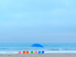 A cheerful family setting up colorful beach chairs and umbrellas on a sunny Oak Island shore.