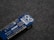 A blue Arduino MKR WiFi 1010 microcontroller board placed on a gray fabric surface. The board features numerous metal pins along one side and is marked with white text identifying its model and specifications.