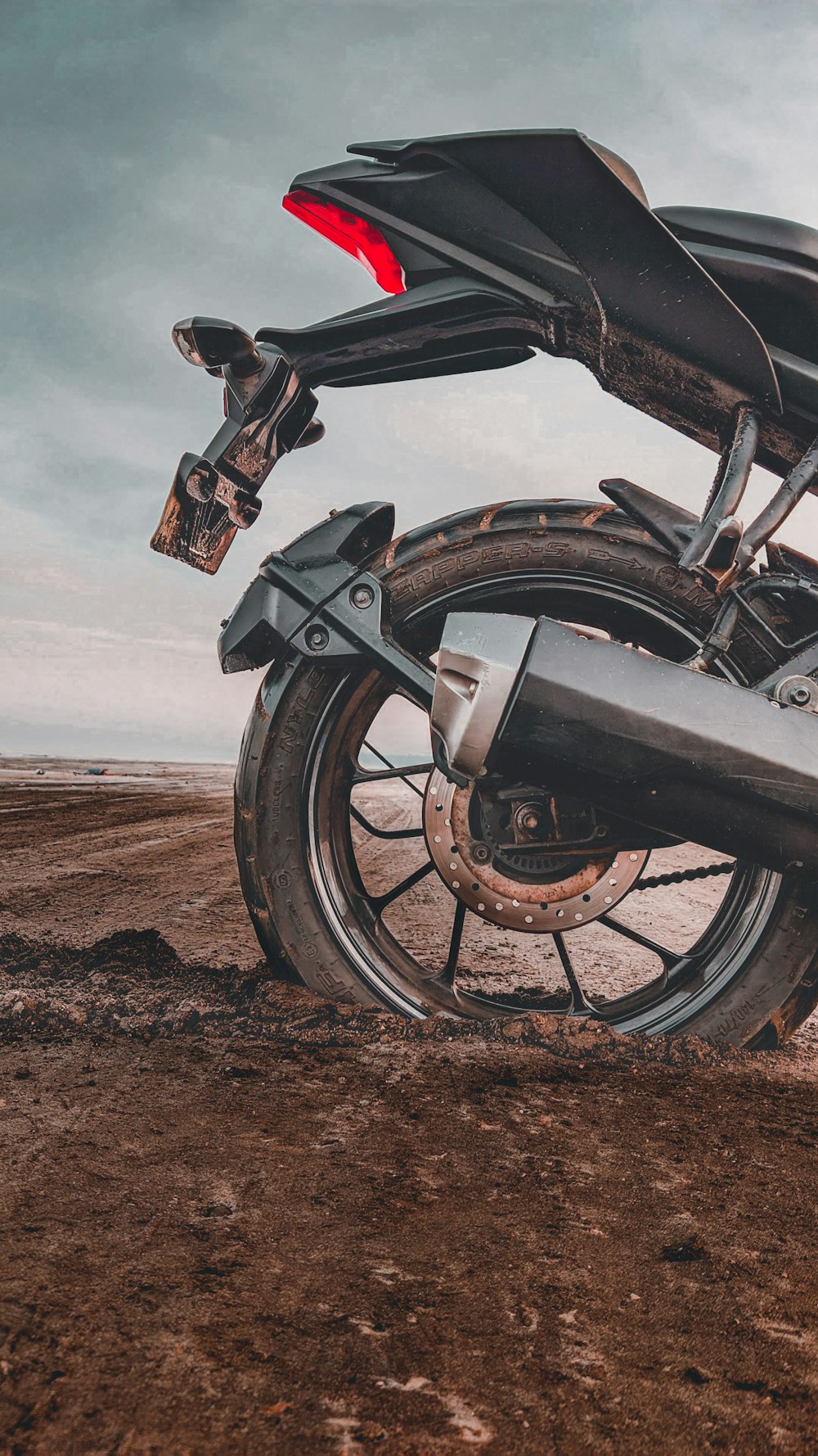 black motorcycle on brown sand during daytime