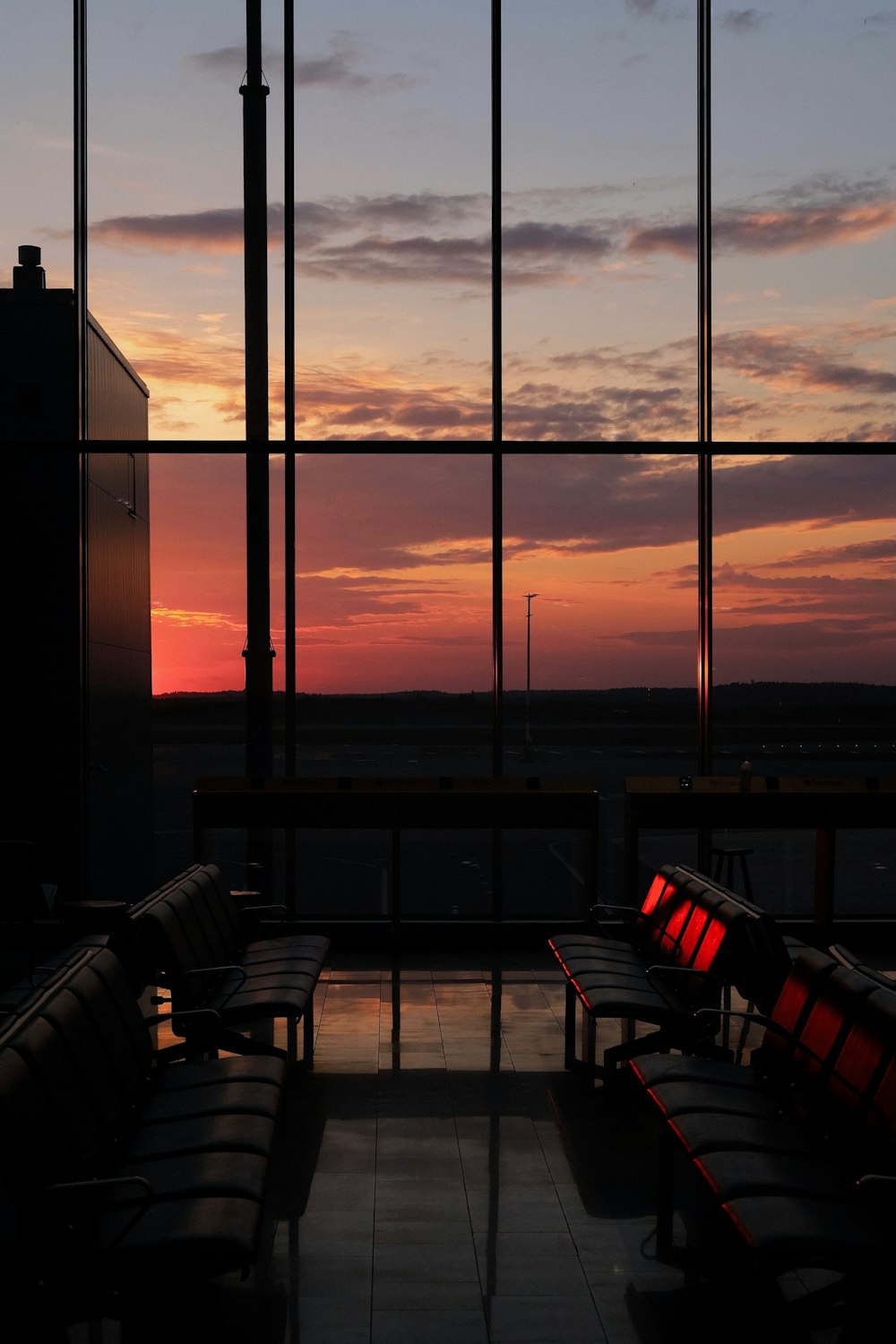 black chairs and tables near glass window during sunset